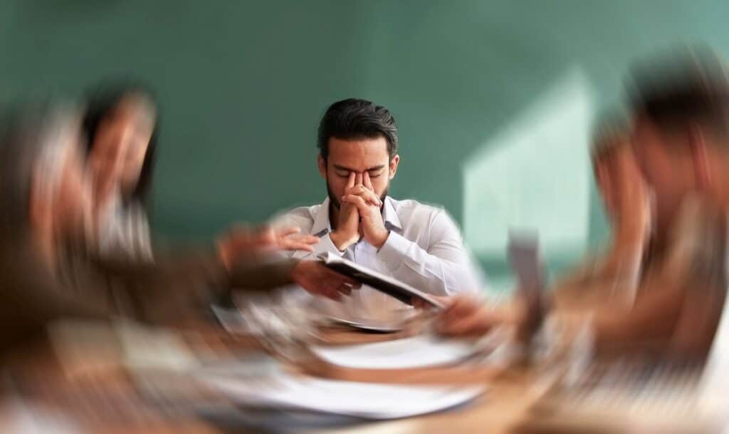 Mann im Meeting mit sichtbarer Erschöpfung durch Brain Fog, mögliche Folge stiller Entzündung, unterstützt durch krillöl